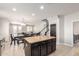 View of the kitchen with dark cabinetry and center island open to the living area at 20709 W Delaney Dr, Buckeye, AZ 85396