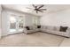 Cozy carpeted Gathering room with neutral walls, ceiling fan, and French doors leading to backyard pool at 20709 W Delaney Dr, Buckeye, AZ 85396