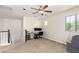 Bright living space features a ceiling fan, desk and natural light from a window at 20709 W Delaney Dr, Buckeye, AZ 85396