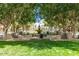 Serene park view with a central fountain, lush greenery, and shaded seating areas at 20709 W Delaney Dr, Buckeye, AZ 85396