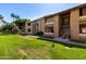 Exterior view of condo building with well-maintained lawn and mature trees at 2146 W Isabella Ave # 131, Mesa, AZ 85202