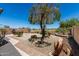 Charming backyard featuring gravel, mature landscaping and desert plants, creating a serene outdoor space at 21563 N Greenway Rd, Maricopa, AZ 85138