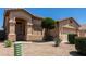 Close up view of the front exterior of this house with a green tree and gravel front yard at 21563 N Greenway Rd, Maricopa, AZ 85138