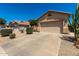 View of the front of this single story house, showing the 2-car garage and desert landscaping at 21563 N Greenway Rd, Maricopa, AZ 85138