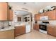 Well-maintained kitchen with tile flooring and wood cabinets, featuring modern appliances at 21563 N Greenway Rd, Maricopa, AZ 85138