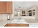 Bright kitchen features a sink, tan countertops, and a view into an adjacent living space at 21563 N Greenway Rd, Maricopa, AZ 85138