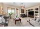 Spacious living room with neutral carpet, ceiling fan, and large windows for natural light at 21563 N Greenway Rd, Maricopa, AZ 85138