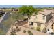 View of the home's backyard, showing a small patio, desert landscaping, and tall perimeter wall at 2406 N 142Nd Ave, Goodyear, AZ 85395