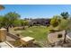 Backyard view from a balcony, showcasing landscaping and neighboring houses with a community lawn at 2406 N 142Nd Ave, Goodyear, AZ 85395