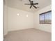 Neutral bedroom featuring carpeted floors, a ceiling fan, and a window allowing ample natural light to brighten the space at 2406 N 142Nd Ave, Goodyear, AZ 85395
