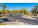 Gated community entrance with stone pillars and professional landscaping with mature trees and signage at 2406 N 142Nd Ave, Goodyear, AZ 85395