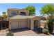View of the home's exterior showcasing the three-car garage and desert landscaping at 2406 N 142Nd Ave, Goodyear, AZ 85395