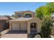 Two-story home with a three-car garage, desert landscaping, and a charming front porch at 2406 N 142Nd Ave, Goodyear, AZ 85395