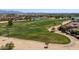 Aerial view of a well-maintained golf course with a pond, lush greenery, and mature trees at 2406 N 142Nd Ave, Goodyear, AZ 85395