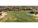 Scenic golf course view featuring lush green fairways, sand traps, and a tranquil pond on a sunny day at 2406 N 142Nd Ave, Goodyear, AZ 85395