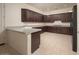 Expansive kitchen with ample dark cabinetry, tile floors, granite countertops, and modern appliances, perfect for cooking at 2406 N 142Nd Ave, Goodyear, AZ 85395