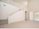 Bright living room featuring high ceilings, neutral carpet, a staircase, and large windows, creating an open atmosphere at 2406 N 142Nd Ave, Goodyear, AZ 85395