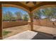 Covered patio with brick columns overlooks the spacious yard with block fencing at 2406 N 142Nd Ave, Goodyear, AZ 85395