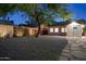 Backyard at twilight features a stone pathway, mature tree, brick house and updated shed with exterior lighting at 2534 N 10Th St, Phoenix, AZ 85006