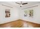 Bright bedroom with hardwood floors, white walls, ceiling fan, and double-hung windows overlooking the neighborhood at 2534 N 10Th St, Phoenix, AZ 85006