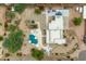 An aerial view captures this property's pool, multiple umbrellas, covered patio, and mature landscaping at 3019 W Trail Dr, Phoenix, AZ 85086