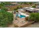 This aerial photo shows a pool with multiple seating areas, a firepit, and mature trees in the backyard at 3019 W Trail Dr, Phoenix, AZ 85086