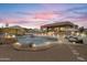 Backyard with a luxurious private pool, desert landscaping, and elegant patio furniture under sunset at 3019 W Trail Dr, Phoenix, AZ 85086