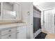 Classic bathroom featuring a white vanity, mirror, and a shower with a patterned curtain and door to the exterior at 3019 W Trail Dr, Phoenix, AZ 85086