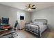 Cozy bedroom with ceiling fan, carpeted floor, desk, chair and a white metal bed frame and light blue bedding at 3019 W Trail Dr, Phoenix, AZ 85086
