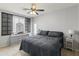 Stylish bedroom featuring a ceiling fan, gray walls, carpeted floors and a black metal framed bed with gray patterned bedding at 3019 W Trail Dr, Phoenix, AZ 85086