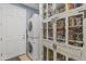 Functional laundry room featuring stacked washer/dryer units, storage and tiled floor with utility closet at 3019 W Trail Dr, Phoenix, AZ 85086