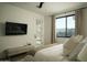 Cozy bedroom with a comfortable bed, modern TV, and a view of the outdoor space at 3101 E Sells Dr, Phoenix, AZ 85016