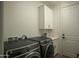 Modern laundry room featuring a GE washer and dryer set, white cabinetry, and clean, bright finishes at 3101 E Sells Dr, Phoenix, AZ 85016