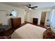 Cozy bedroom with a ceiling fan, dresser, and doors to both a closet and the bathroom at 3314 N 68Th St # 107, Scottsdale, AZ 85251