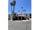 Complex building with tile roof entrance under blue sky and tall palm trees at 3314 N 68Th St # 107, Scottsdale, AZ 85251