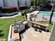 Aerial shot of pool area includes stainless steel grill, dining set, and well-kept landscaping at 3314 N 68Th St # 107, Scottsdale, AZ 85251