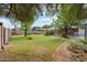 Expansive backyard featuring a lush green lawn, mature trees, and a covered patio at 3616 E Fairmount Ave, Phoenix, AZ 85018