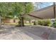 Spacious carport overlooking the green backyard with a brick-lined concrete surface at 3616 E Fairmount Ave, Phoenix, AZ 85018