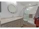 Bathroom featuring a round mirror, spacious vanity, and a modern glass-enclosed shower at 3830 E Lakewood E Pkwy # 1007, Phoenix, AZ 85048