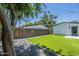 A beautiful backyard features artificial turf, mature trees, and secure fencing for outdoor enjoyment and privacy at 47 Spur Cir, Scottsdale, AZ 85251
