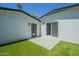 The house features a private patio area accessible through sliding glass doors, set against well-maintained artificial grass at 47 Spur Cir, Scottsdale, AZ 85251