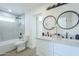 Bathroom with double vanity, modern lighting, and tiled shower and tub at 47 Spur Cir, Scottsdale, AZ 85251