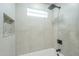 Close up of tiled tub and shower combination featuring rain shower head and tiled shower niche at 47 Spur Cir, Scottsdale, AZ 85251