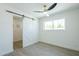 Spare bedroom with sliding barn door entry to the closet and a large window at 47 Spur Cir, Scottsdale, AZ 85251