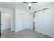 Bright bedroom featuring barn door to bathroom, wood-look tile flooring, and a ceiling fan at 47 Spur Cir, Scottsdale, AZ 85251