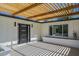 Modern entryway with black trimmed front door and wood pergola at 47 Spur Cir, Scottsdale, AZ 85251