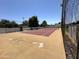 Community tennis court that features a fenced perimeter and red clay surface at 47 Spur Cir, Scottsdale, AZ 85251