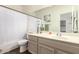Bathroom with a single sink vanity, a large mirror, and a shower-tub combo at 623 W Harvard Ave, Gilbert, AZ 85233