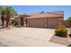 Charming home exterior featuring a wide driveway leading to a spacious garage with a well-kept lawn at 623 W Harvard Ave, Gilbert, AZ 85233
