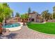 Expansive backyard featuring a sparkling pool, lush green lawn, mature trees, and outdoor living space at 635 N Yale Dr, Gilbert, AZ 85234